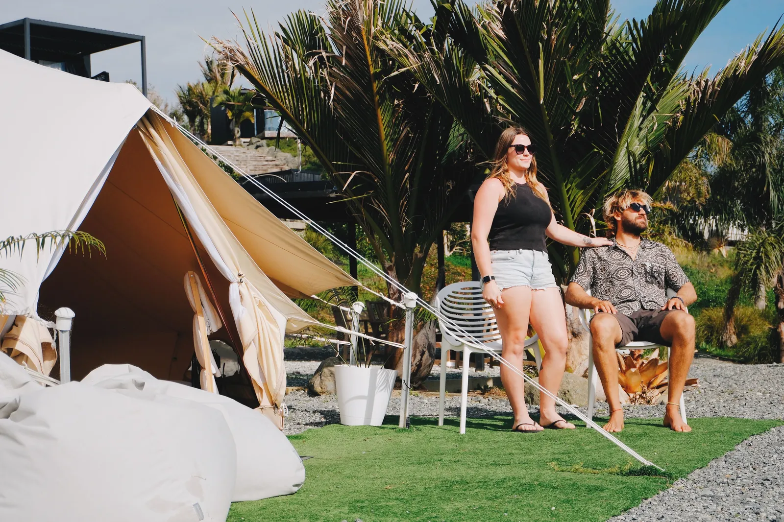 Couple relaxing outside their glamping teepee at Te Arai