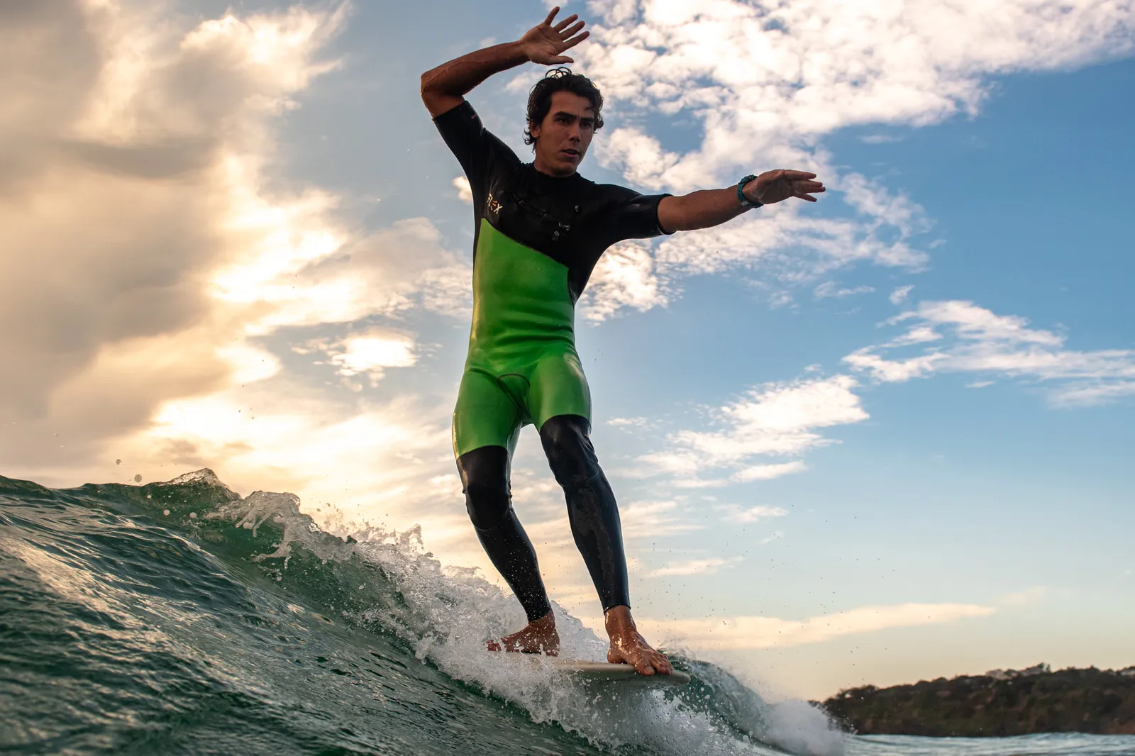 Adult surfer riding a golden hour wave in New Zealand